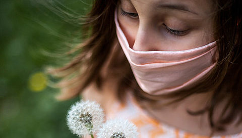 Mädchen mit Maske und Pusteblume
